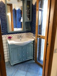 y baño con lavabo azul y espejo. en Capri Sun, en Anacapri