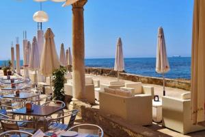 una fila di tavoli e sedie con ombrelloni sulla spiaggia di SUITE JINETES a Málaga