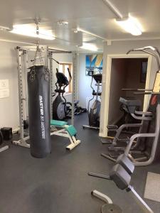a gym with a punching bag hanging from the ceiling at Cosy compact living with gym access. in Heberg