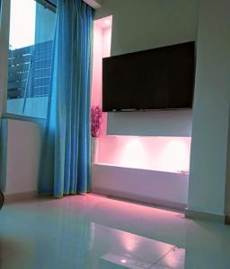 Uma televisão e/ou sistema de entretenimento em Haris white apartment
