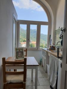 トラモンティにあるHoliday house-Amalfi Coast Tramonti-Come una Voltaのキッチン(テーブル付)、大きな窓が備わります。