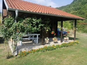a picnic shelter with a bench in a garden at Galerija68 in Kraljevo