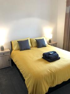 a yellow bed with a backpack on top of it at The Moo House 2 bed Property - STAYSEEKERS in Salisbury