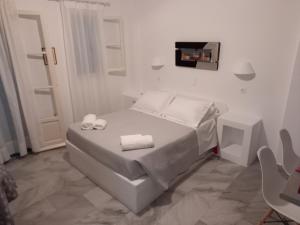 a white bedroom with a bed with two towels on it at Nefeli in Drios