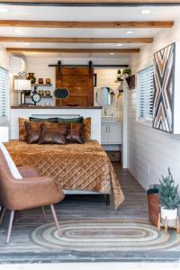 a bedroom with a bed and a chair at Deer Creek Tiny Container Home-12 Min to Magnolia in Bellmead