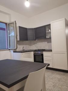 eine Küche mit weißen Schränken und einer schwarzen Arbeitsplatte in der Unterkunft Appartamento Mare Sardegna Siniscola a 6 km da La Caletta Santa Lucia Capo Comino Berchida in Siniscola