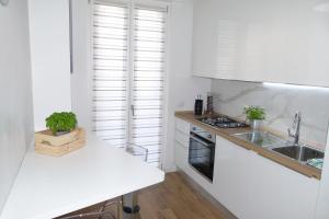uma cozinha branca com um lavatório e um balcão em My Home Saronno em Saronno