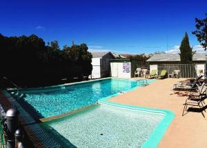 - une piscine d'eau bleue dans la cour dans l'établissement El Portal Motel, à Beatty