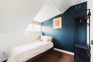um quarto com uma parede azul e uma cama em Entire Property in Hoole, Chester- walking distance to train station & city centre em Chester