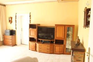 a living room with a tv on a wooden entertainment center at Ferienhaus Groß Dratow in Groß Dratow
