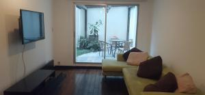 a living room with a couch and a tv and a table at 1430 Luxury Suite Edificio Avadell- Bellavista-Quito in Quito