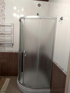 a shower with a glass door in a bathroom at Apartment Ivashchenka 1a in Luts'k