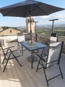 uma mesa e cadeiras com um guarda-sol no telhado em Alba Del Borgo em Recanati