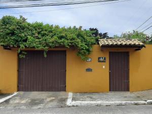 two garage doors with a hedge on top of it at VILLA COIMBRA in Lauro de Freitas