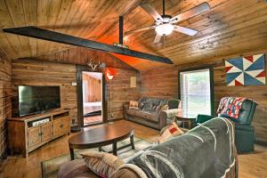 a living room with a couch and a ceiling fan at 1950s Serenity Pond Cabin with View Peace and Quiet! in Talladega