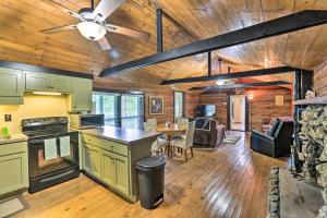 a kitchen and living room in a log cabin at 1950s Serenity Pond Cabin with View Peace and Quiet! in Talladega