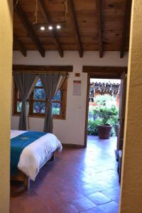 a bedroom with a bed in a room with windows at Hotel La Casona Real in Huasca de Ocampo
