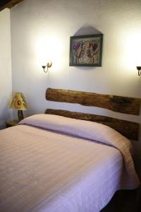 a bedroom with a bed and two lights on the wall at Hotel La Casona Real in Huasca de Ocampo