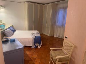 カポリーヴェリにあるVilla Soprana by Agenzia SolturElbaの小さなベッドルーム(ベッド1台、椅子付)