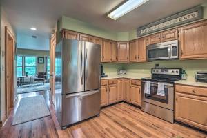 a kitchen with wooden cabinets and a stainless steel refrigerator at Lake Placid Retreat Less Than 1 Mi to Mirror Lake Beach! in Lake Placid