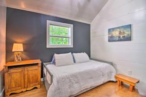 Un dormitorio pequeño con una cama y una ventana. en Stylish Mountain Home Near Ski, Golf and Manchester!, en Bondville