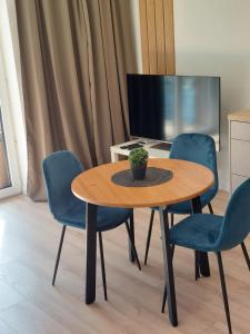 Cette chambre comprend une table et des chaises. dans l'établissement Apartament LindEGO, à Toruń