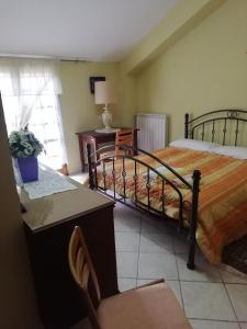 a bedroom with a bed and a desk and a chair at B&B PASSO DEL FALCO in Sorianello