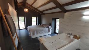 um quarto com uma cama e uma banheira num quarto em A Casa de Costa em Laxe