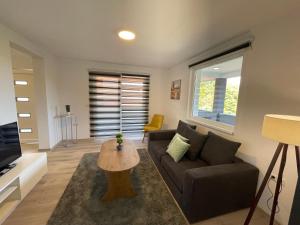 een woonkamer met een bank en een tafel bij Ammirevole Ravne Apartments in Visoko