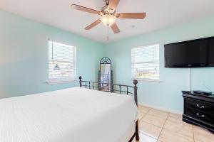 a bedroom with a bed and a ceiling fan at Sandpiper Villa in Galveston