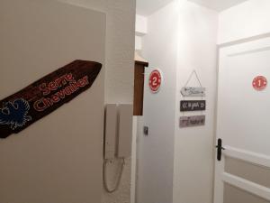 ein Schild an einer Wand neben einer Tür in der Unterkunft Appartement 4 personnes Serre Chevalier Montagne/Contemporain Refait à neuf in La Salle Les Alpes + 7 Fotos