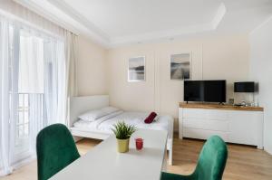 a white room with a bed and a table and chairs at ApartHouse Deluxe in Łódź