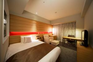 Cette chambre comprend un lit et un bureau. dans l'établissement Hotel Metropolitan Akita, à Akita