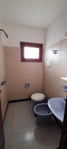 a bathroom with a toilet and a sink at Hotel Capri in Villa Gesell +28 photos