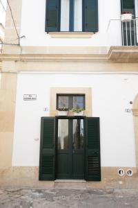 una porta con persiane verdi su un edificio bianco di Giulia's House a Galatina