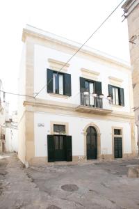 Edificio blanco con puertas negras y balcón en Giulia's House, en Galatina