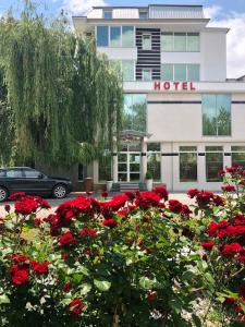 a hotel with red flowers in front of a building at Hotel Royal in Tetovo
