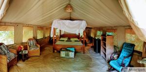 1 camera da letto in una tenda con letto e sedie di Firefly Eco Retreat a Shimoni