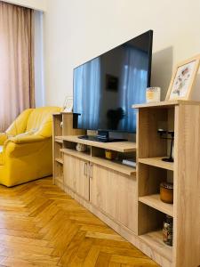 una sala de estar con TV en un centro de entretenimiento de madera en Postavarului Apartment en Braşov
