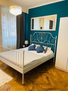 a bedroom with a bed with a blue wall at Postavarului Apartment in Braşov