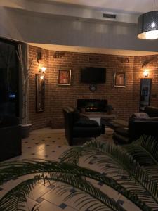 a living room with a fireplace and a tv on a brick wall at Hotel Royal in Tetovo