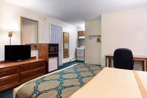 a hotel room with a bed and a flat screen tv at Royal Inn Clearfield in Clearfield +18 photos