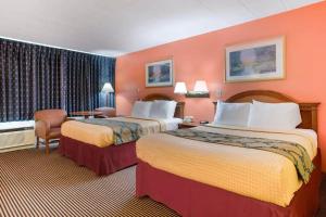 two beds in a hotel room with orange walls at Royal Inn Clearfield in Clearfield