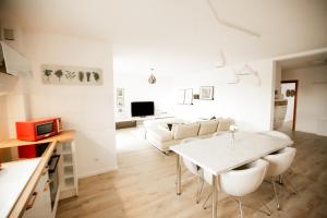a white living room with a table and chairs at bonquartier - groß & stylisch - zentral & komfortabel in Siegburg