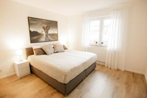 a bedroom with a bed with a painting on the wall at bonquartier - groß & stylisch - zentral & komfortabel in Siegburg
