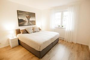 1 dormitorio con 1 cama con una pintura en la pared en bonquartier - groß & stylisch - zentral & komfortabel, en Siegburg