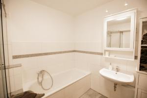 a white bathroom with a sink and a bath tub at bonquartier - groß & stylisch - zentral & komfortabel in Siegburg