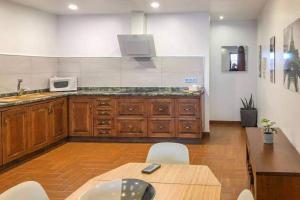 a kitchen with wooden cabinets and a table and a microwave at LA CASITA DE BARTOLO in San Bartolomé