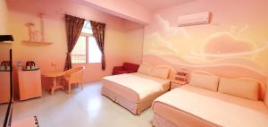 una camera d'albergo con due letti e una scrivania di 清清之家 DingDing Home a Città Vecchia di Hengchun