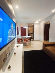 a living room with a large flat screen tv at Premium Flat Praia Calma - PontaNegra in Natal